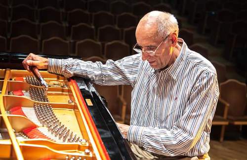 Николай Кузичкин за настройкой музыкального инструмента. Фото из семейного архива, предоставлено "Кавказскому узлу" супругой Кузичкина. Николай Кузичкин за настройкой музыкального инструмента. Фото из семейного архива, предоставлено "Кавказскому узлу" супругой Кузичкина.