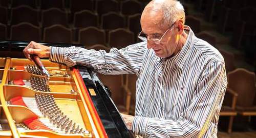 Николай Кузичкин за настройкой музыкального инструмента. Фото из семейного архива, предоставлено "Кавказскому узлу" супругой Кузичкина. Николай Кузичкин за настройкой музыкального инструмента. Фото из семейного архива, предоставлено "Кавказскому узлу" супругой Кузичкина.