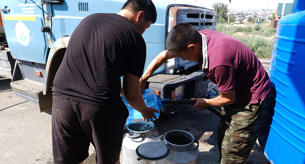 Жители Элисты набирают воду в бидоны для воды. Фото: riakalm.ru
