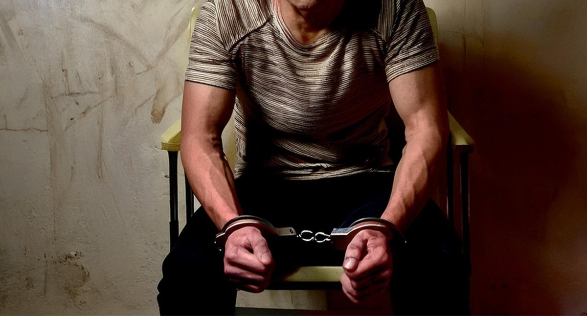 Задержанный в наручниках. Иллюстрация создана «Кавказским узлом» с помощью ИИ в программе Photoshop
