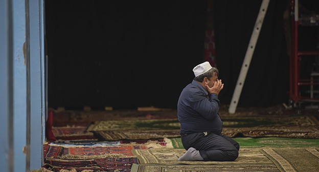 Верующий во время молитвы. Фото Елены Синеок, "Юга.ру"