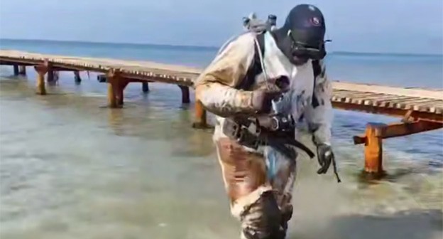 Водолаз несет грунт с мазутом. Скриншот видео от 1 апреля 2025 г. https://t.me/opershtab23/13060