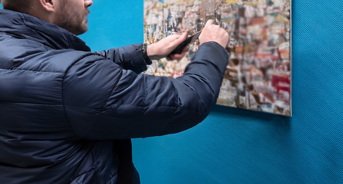 Мужчина портит постер. Иллюстрация создана "Кавказским узлом" с помощью ИИ в программе Photoshop