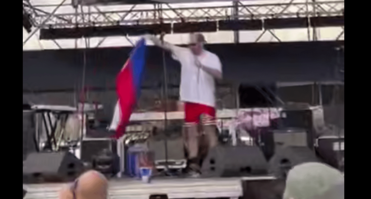 Эрекле Гецадзе с российским флагом. Стоп-кадр видео Tbilisi Life от  25.05.25, https://t.me/Tbilisi_life/39793.