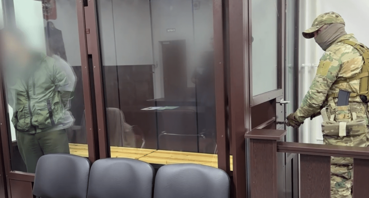 Бывший силовик (слева) и конвойный в зале суда. Стоп-кадр видео из Telegrram-канала управления СКР по Ингушетии от 07.06.25, https://t.me/su_skr06/3793