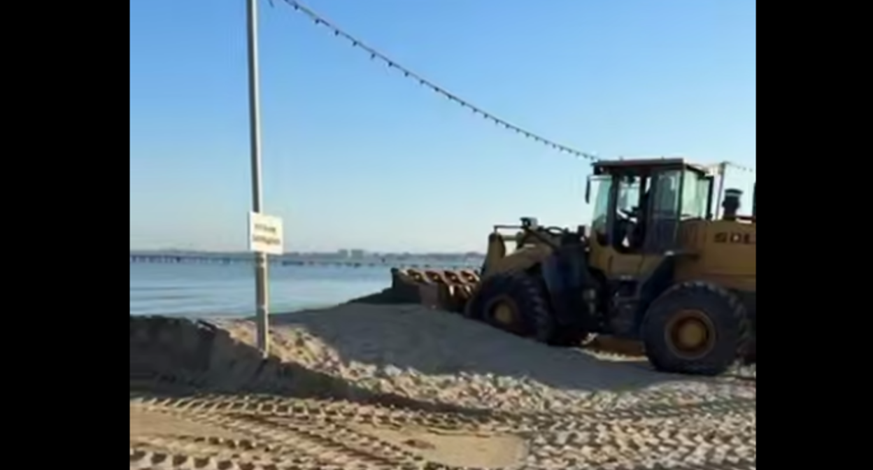 Экскаватор убирает защитный вал на пляже в Анапе. Стоп-кадр видео оперштаба Краснодарского края от 05.07.25, https://t.me/opershtab23/13690.