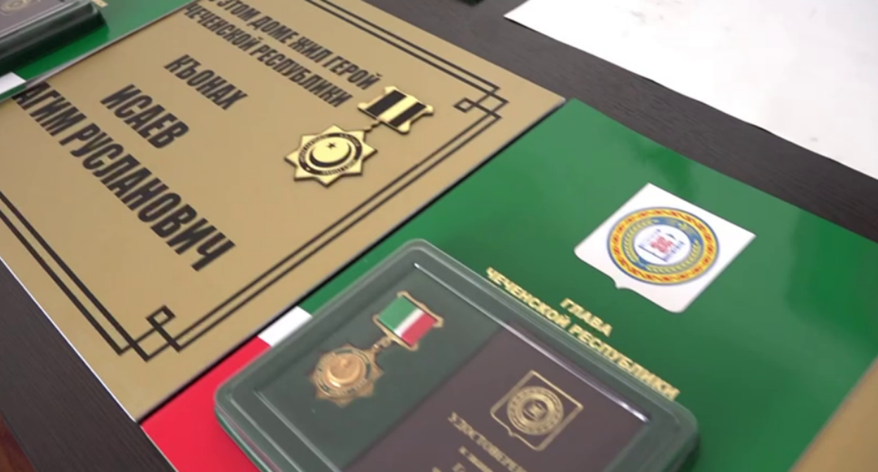 Мемориальная доска и награда убитому бойцу. Стоп-кадр видео префектуры Висаитовского района от 06.09.25, https://t.me/visaitovskayaprefertura/1617
