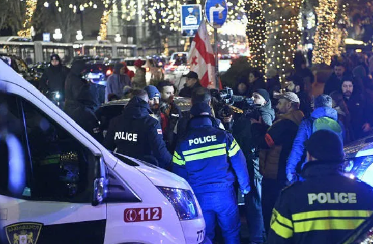 Задержание Давида Асанидзе. Скриншот фото "Интерпрессньюс" от 17.12.25, https://www.interpressnews.ge/ka/article/857612-kashvetis-mimdebared-policiam-akciis-ert-erti-monacile-daakava