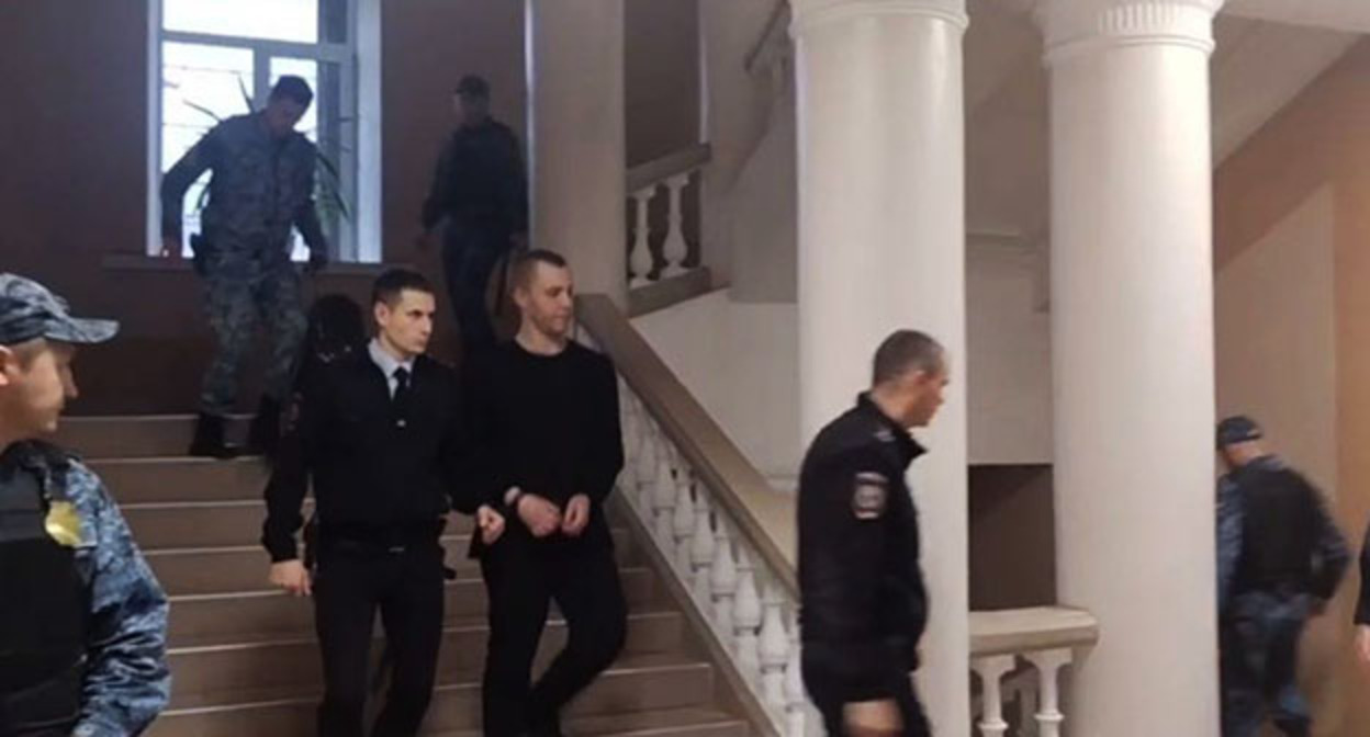 Никита Журавель (в центре) в коридоре суда. Фото: СУ СКР по Волгоградской области