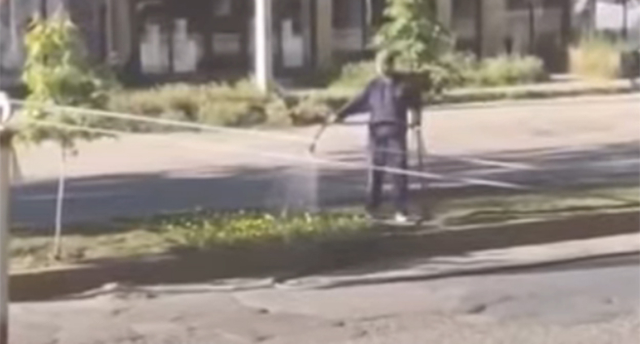 Мэр Избербаша поливает цветы на городской улице. Скриншот видео https://www.instagram.com/reels/DZMjffXNqHW/ принадлежит компании Meta деятельность которой запрещена в России