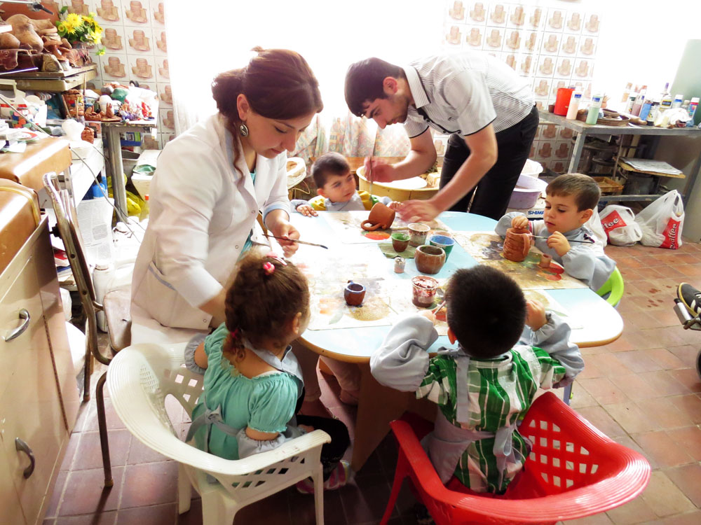 Психолог центра Лусине и Сероб показывают детям как раскрашивать игрушкию Психолог центра Лусине и Сероб показывают детям как раскрашивать игрушкию