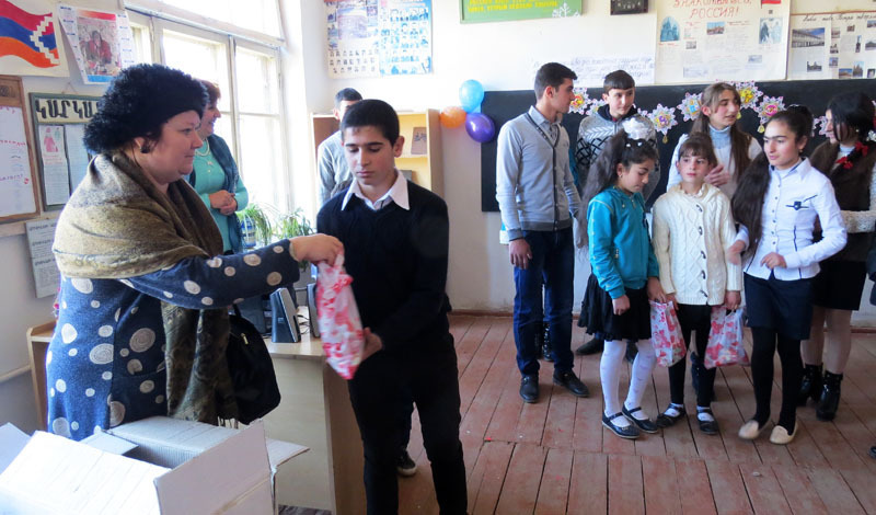 Галина Михайловна, от имени Русской общины, раздаёт подарки детишкам.