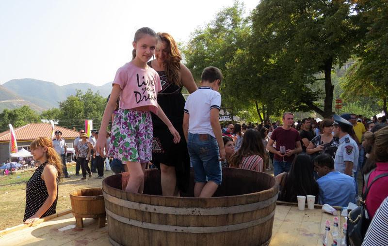 Мамаша с детьми поднялись на помост, где была установлена большая кадка и начали топтать босыми ногами гроздья винограда…