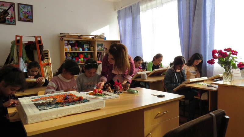 Педагог Яна Савадян проводит урок вышивания гобелена.