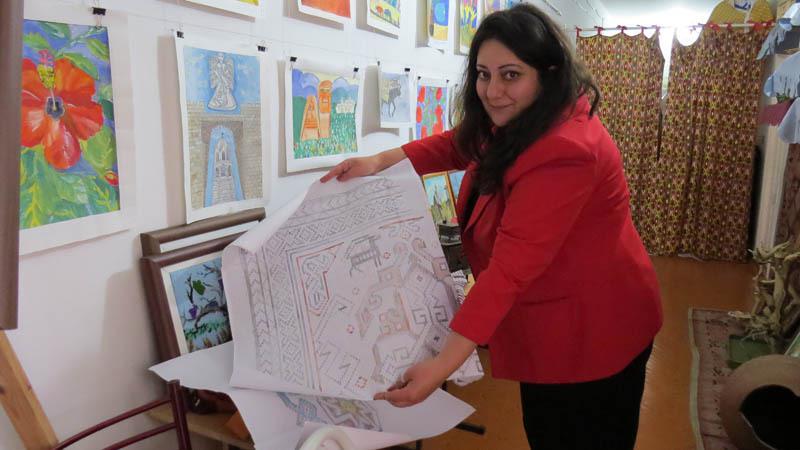 Надежда Саркисян, зам. директора центра показывает схему будущего ковра.