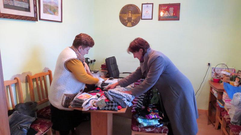 Нонна Мусаелян, директор Степанакертского дома-интерната (слева) и Шогер Григорян перебирают вещи, нами купленные для детишек.